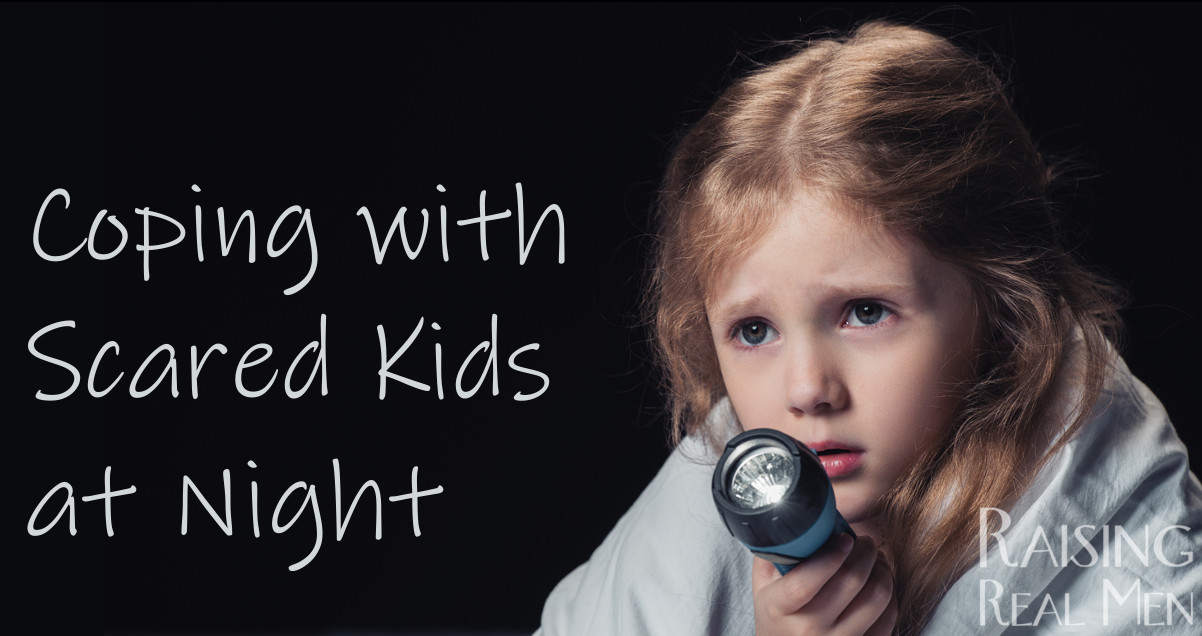 Photo of Frightened Little Girl Under Blanket with Flashlight