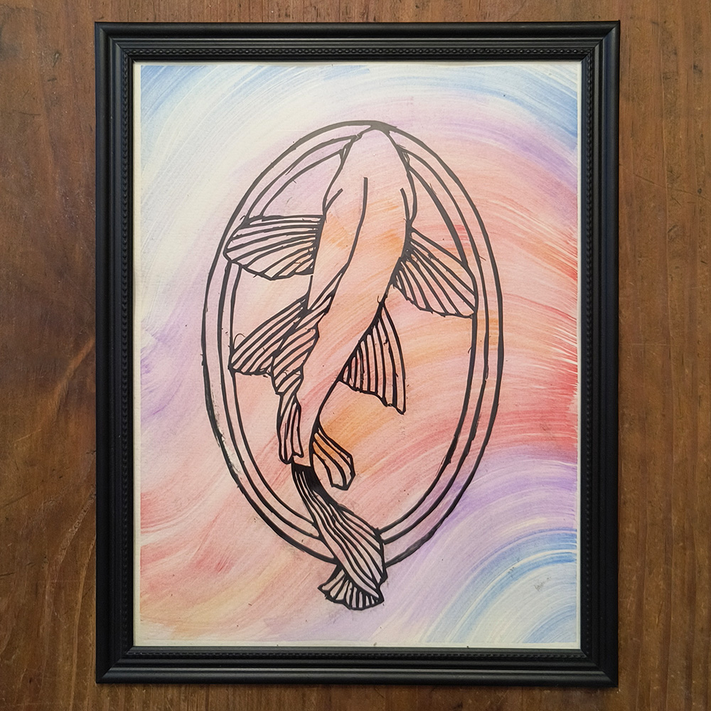 Kirie Koi Fish 1000x1000 A Koi Fish cut into black paper in a Japanese style over a watercolor wash background in a black frame on a wooden table.