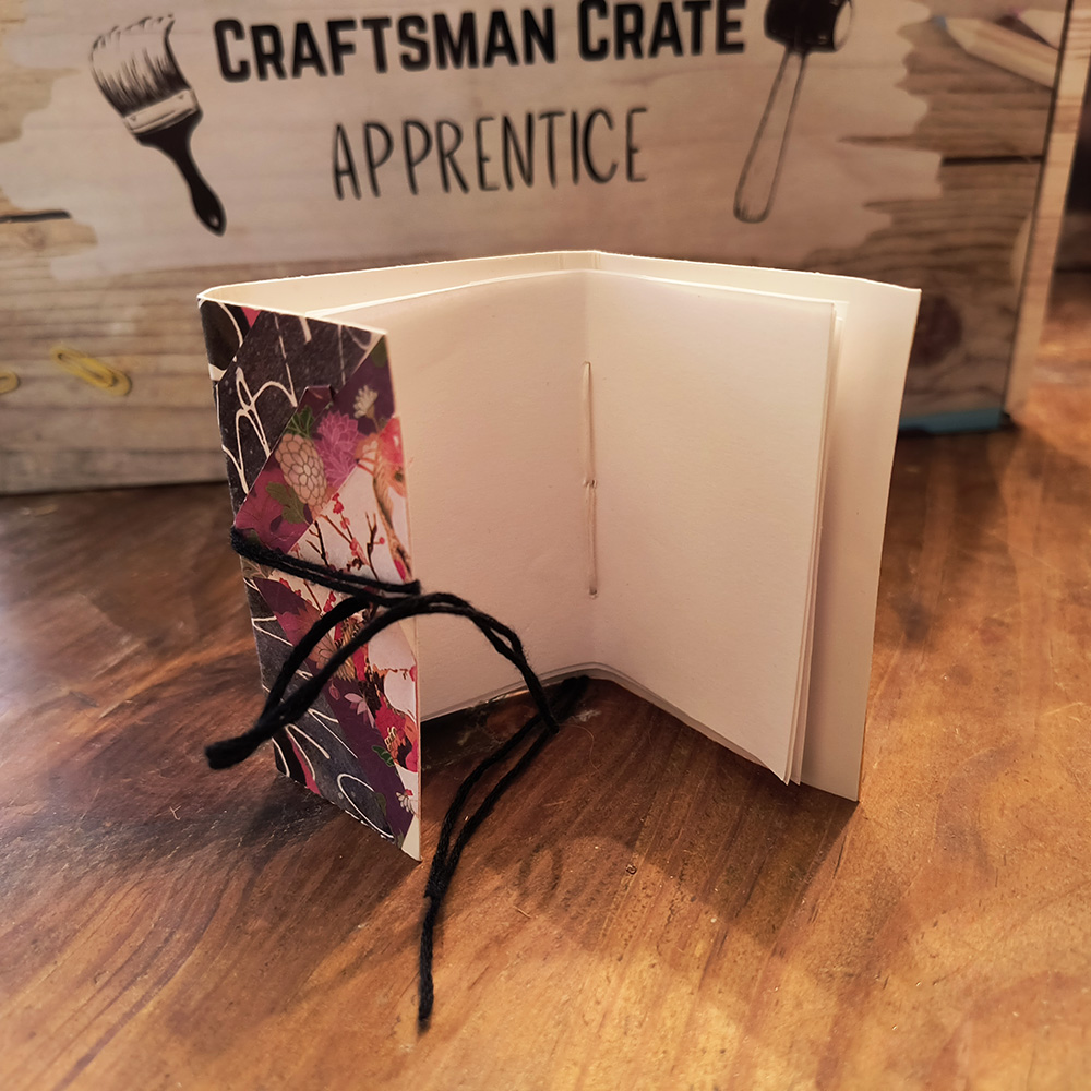 Mini Book Open against Apprentice Box 1000x1000